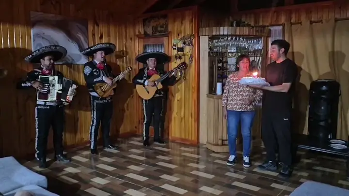 Mariachi cantando el cumpleaños feliz con torta
